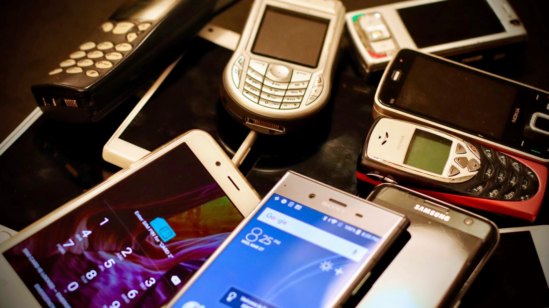 Alte Smartphones und Handys liegen auf einem Haufen