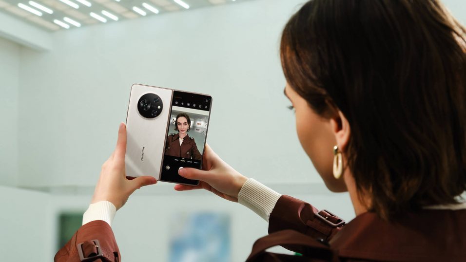 Frau macht Selfie mit aufgeklapptem Tecno Phantom V Fold.
