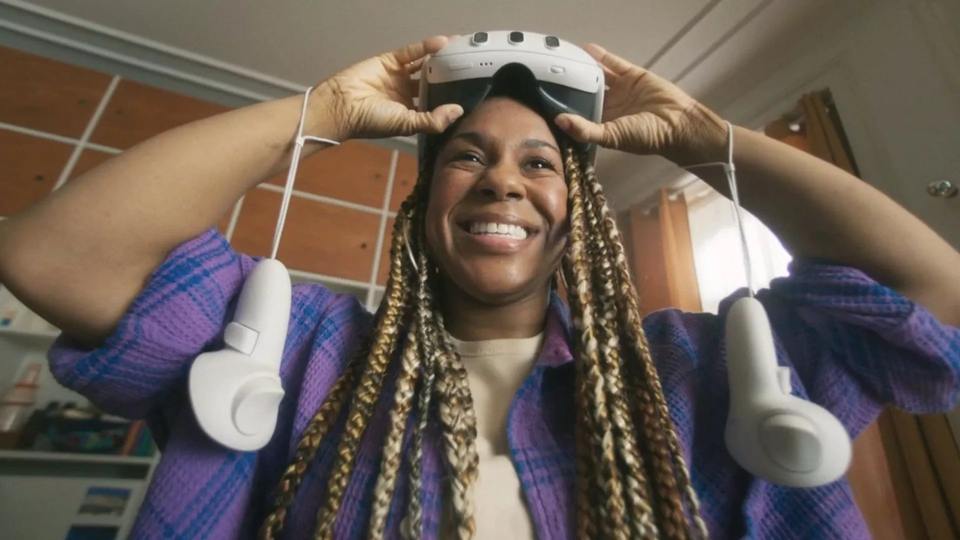 Person mit Meta Quest 3 auf dem Kopf, VR-Controllern an den Handgelenken.