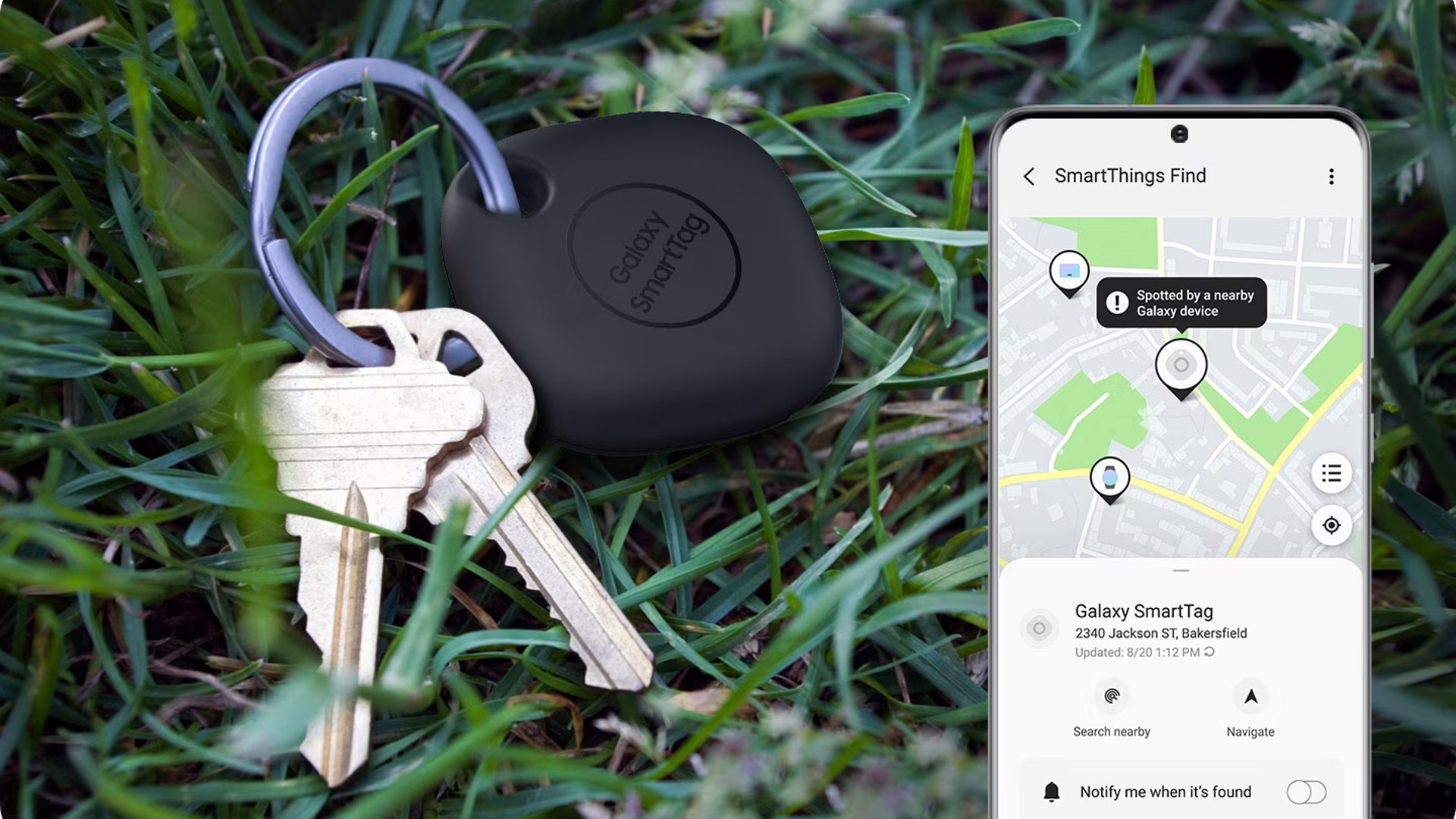 Schlüssel mit Galaxy SmartTag im Gras, daneben Smartphone.