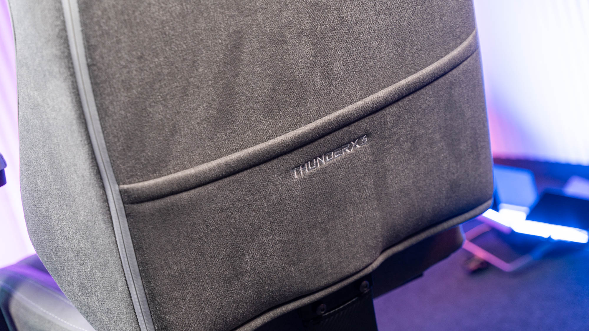 Staufach an Rückseite eines grauen Gaming-Stuhls mit Stoffbezug
