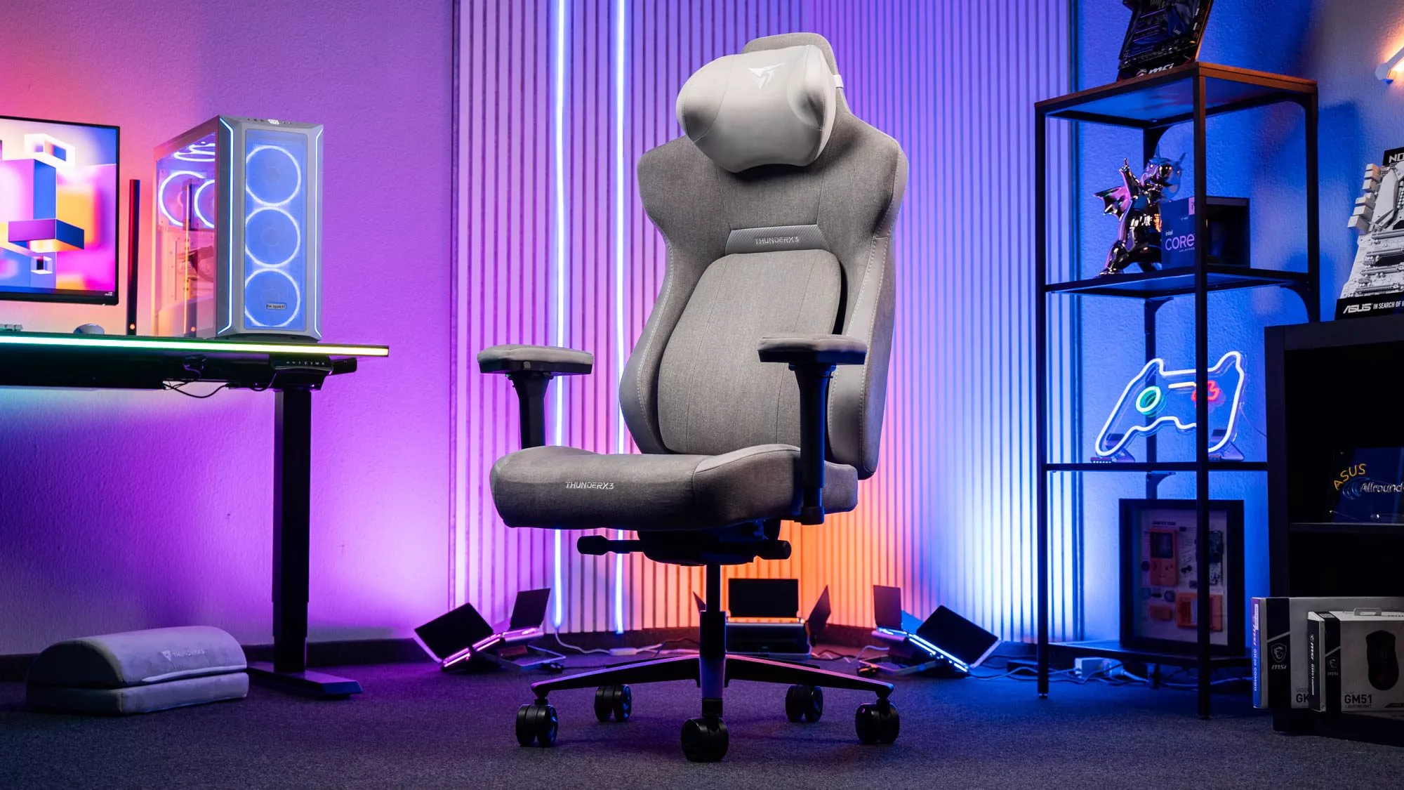 Grauer Gaming-Stuhl vor bunter Beleuchtung und Schreibtisch