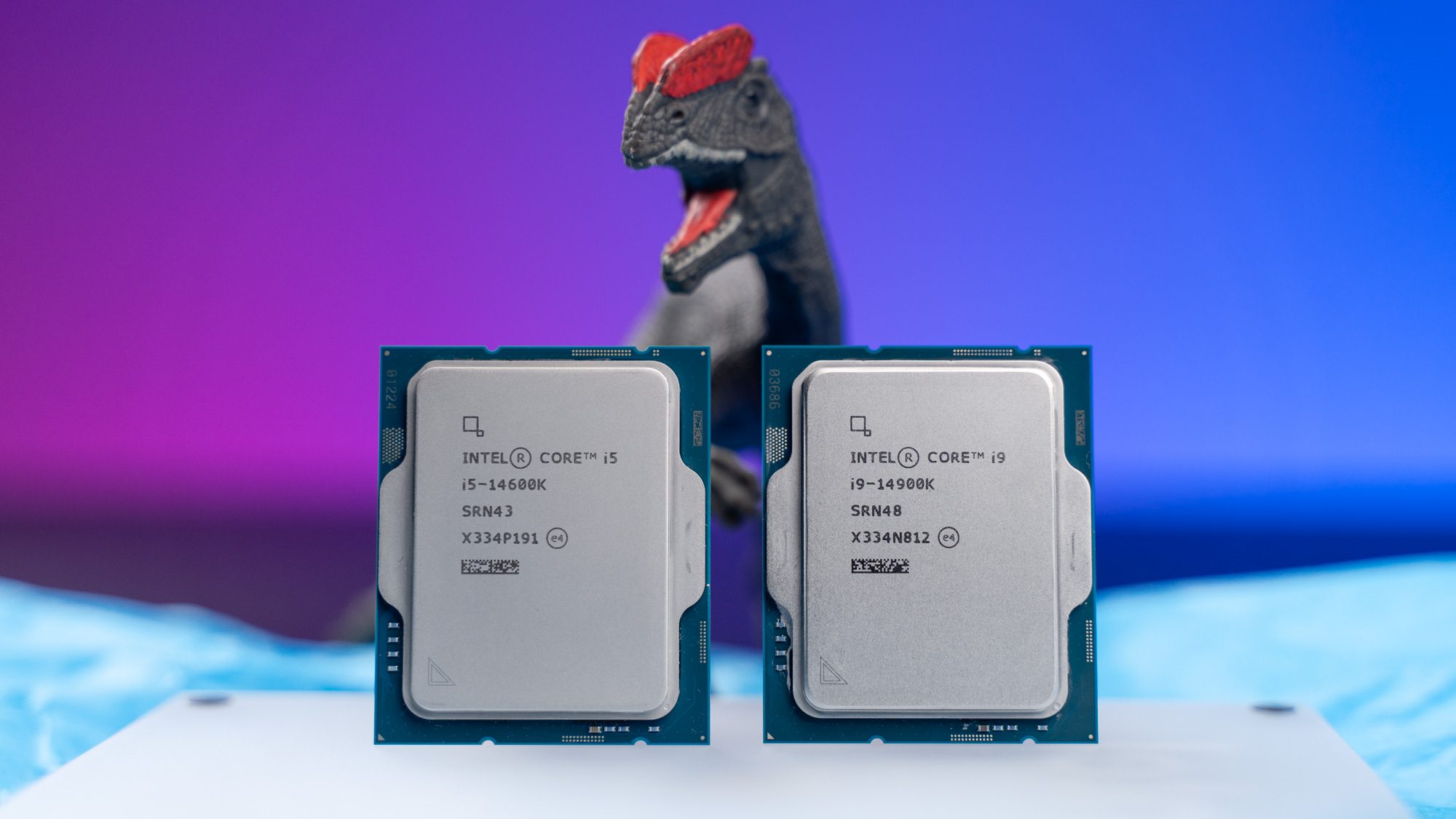 Zwei Intel-Prozessoren der 14. Generation, dahinter ein Spielzeug-Dinosaurier.