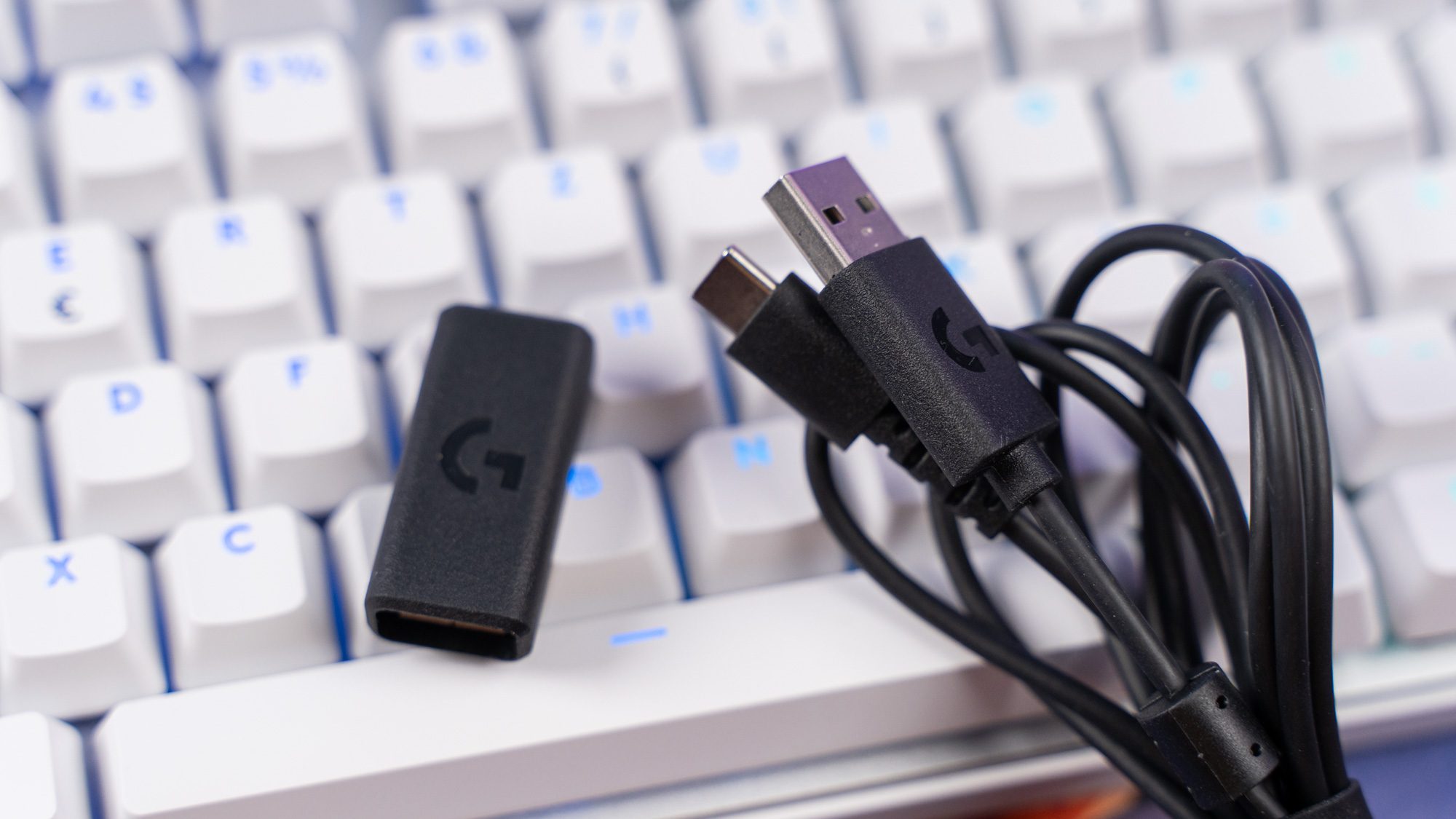 Schwarzes USB-C-Kabel und Dongle auf weißer Tastatur